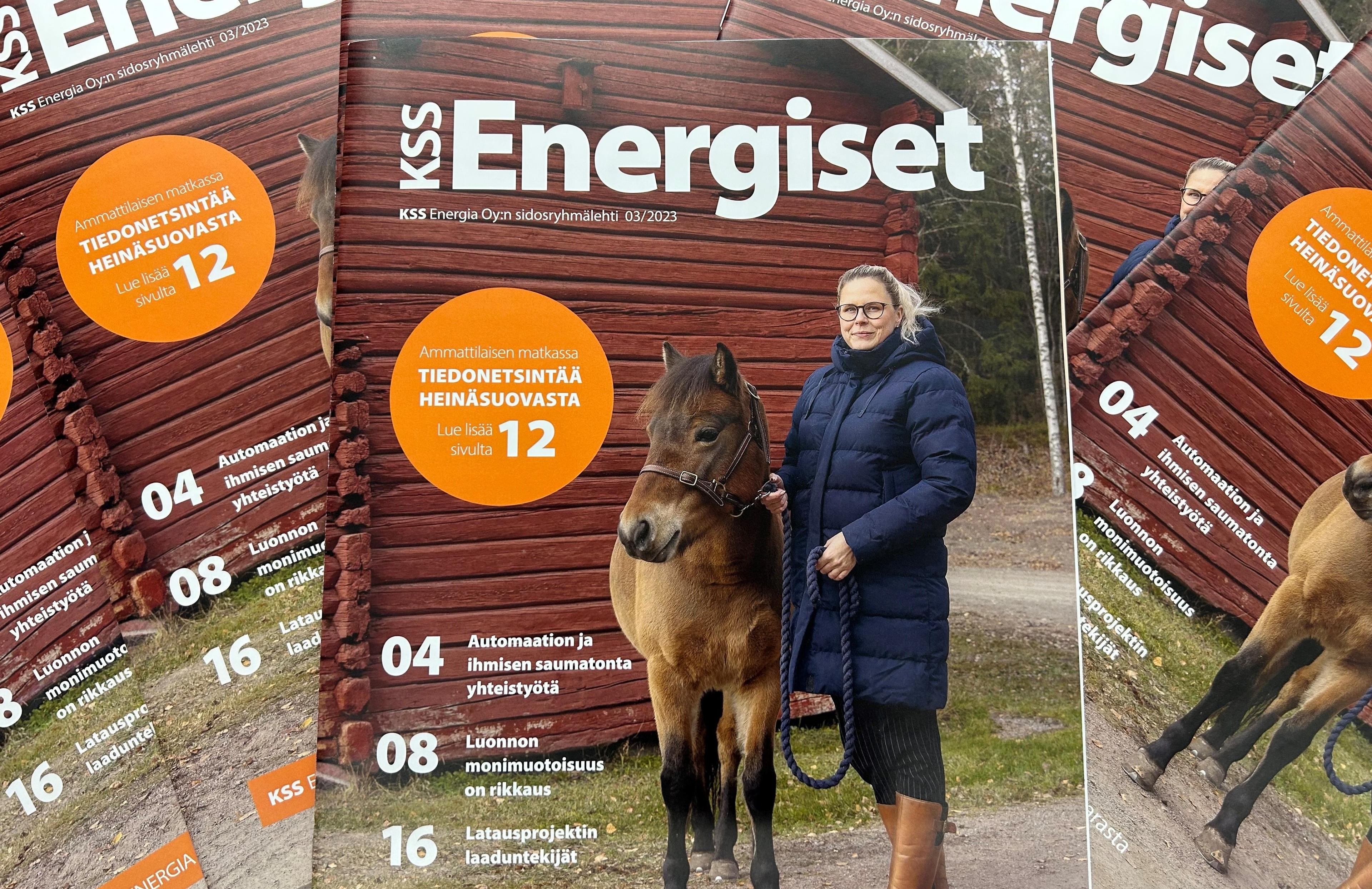 Kuvassa nippu KSS Energiset-lehtiä, joiden kansikuvassa on sinitakkinen vaaleahiuksinen nainen vierellään ruskea poni. Taustalla näkyy punaiseksi maalattu hirsirakennus sekä hiekkatietä, jonka takana kuusimetsää.